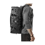 Man carrying the RYZVOX FAR Duffel Bag 40L Travel as a backpack, side view
