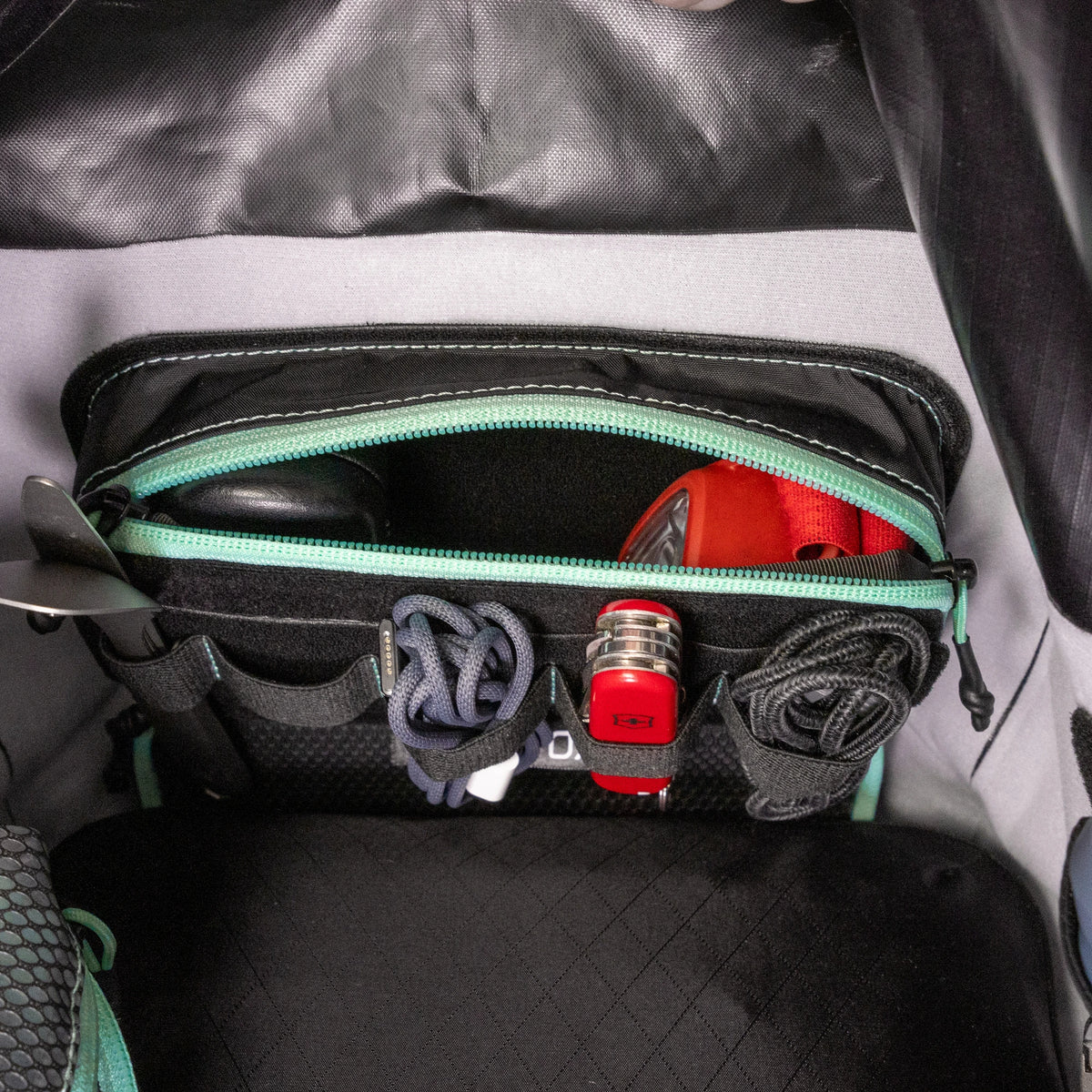 Organizer pouches fitted inside a RYZVOX bag alongside a helmet, bottle and cables