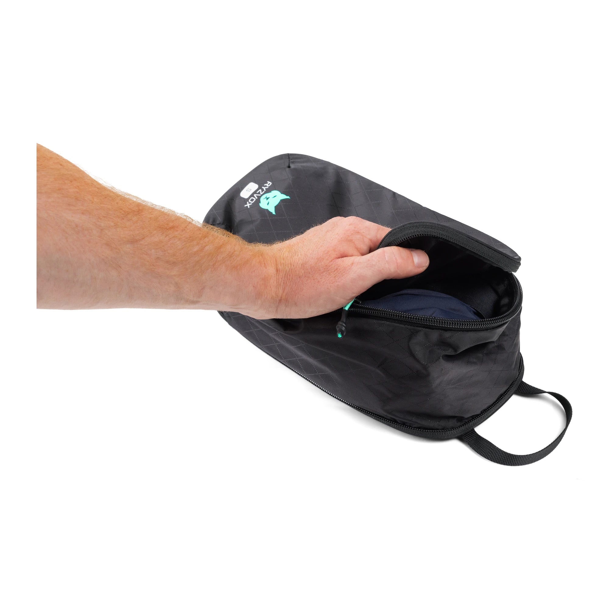 Hand opening the RYZVOX Packing Cube S to show folded clothing packed inside